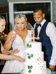Bride and groom cut the cake at wedding reception at a Channel Side Wedding in Palm Coast, Florida. Taken by Ashley Dye Photography, a Jacksonville, Florida Wedding Photographer.