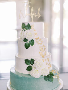 White and blue wedding cake with white roses and gold flecks at wedding reception at a Channel Side Wedding in Palm Coast, Florida. Taken by Ashley Dye Photography, a Jacksonville, Florida Wedding Photographer.