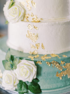 White and blue wedding cake with white roses and gold flecks at wedding reception at a Channel Side Wedding in Palm Coast, Florida. Taken by Ashley Dye Photography, a Jacksonville, Florida Wedding Photographer.