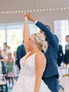 Groom twirls bride on dance floor first dance at wedding reception at a Channel Side Wedding in Palm Coast, Florida. Taken by Ashley Dye Photography, a Jacksonville, Florida Wedding Photographer.
