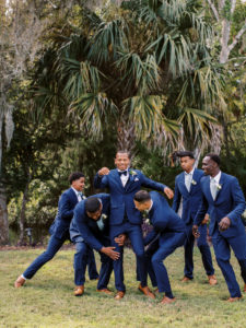 Groomsmen rush to lift groom in the air at a Channel Side Wedding in Palm Coast, Florida. Taken by Ashley Dye Photography, a Jacksonville, Florida Wedding Photographer.
