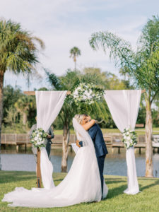 Bride hugging groom at the end of the aisle at a Channel Side Wedding in Palm Coast, Florida. Taken by Ashley Dye Photography, a Jacksonville, Florida Wedding Photographer.