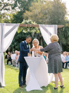 Bride and groom lighting unity candle during ceremony at a Channel Side Wedding in Palm Coast, Florida. Taken by Ashley Dye Photography, a Jacksonville, Florida Wedding Photographer.