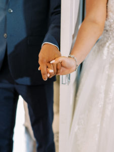 Bride and groom hold hands through the door for intimate moment before ceremony at their Channel Side Wedding in Palm Coast, Florida. Taken by Ashley Dye Photography, a Jacksonville, Florida Wedding Photographer.