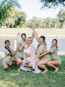 Bridal party in matching pajamas posing with bride at a Channel Side Wedding in Palm Coast, Florida. Taken by Ashley Dye Photography, a Jacksonville, Florida Wedding Photographer.