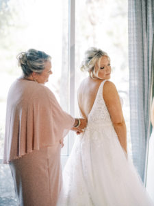 Mom zipping up Wedding Dress at a Channel Side Wedding in Palm Coast, Florida. Taken by Ashley Dye Photography, a Jacksonville, Florida Wedding Photographer.