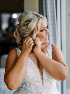 Bride putting on earring at her Channel Side Wedding in Palm Coast, Florida. Taken by Ashley Dye Photography, a Jacksonville, Florida Wedding Photographer.