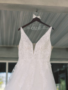 V-Neck Ballgown Wedding Dress hanging from building at a Channel Side Wedding in Palm Coast, Florida. Taken by Ashley Dye Photography, a Jacksonville, Florida Wedding Photographer.