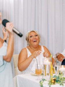 Bride reacts to toasts at wedding reception at a Channel Side Wedding in Palm Coast, Florida. Taken by Ashley Dye Photography, a Jacksonville, Florida Wedding Photographer.