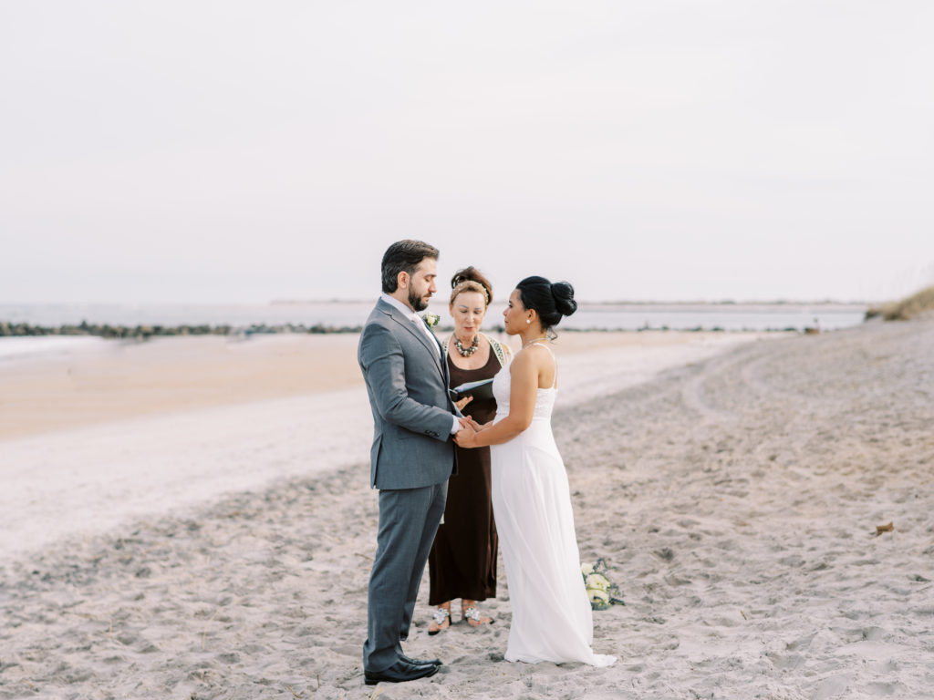 Bride and Groom hold hands for an intimate St. Augustine Beach elopement.  Taken By Ashley Dye, a St. Augustine, Florida Wedding Photographer.
